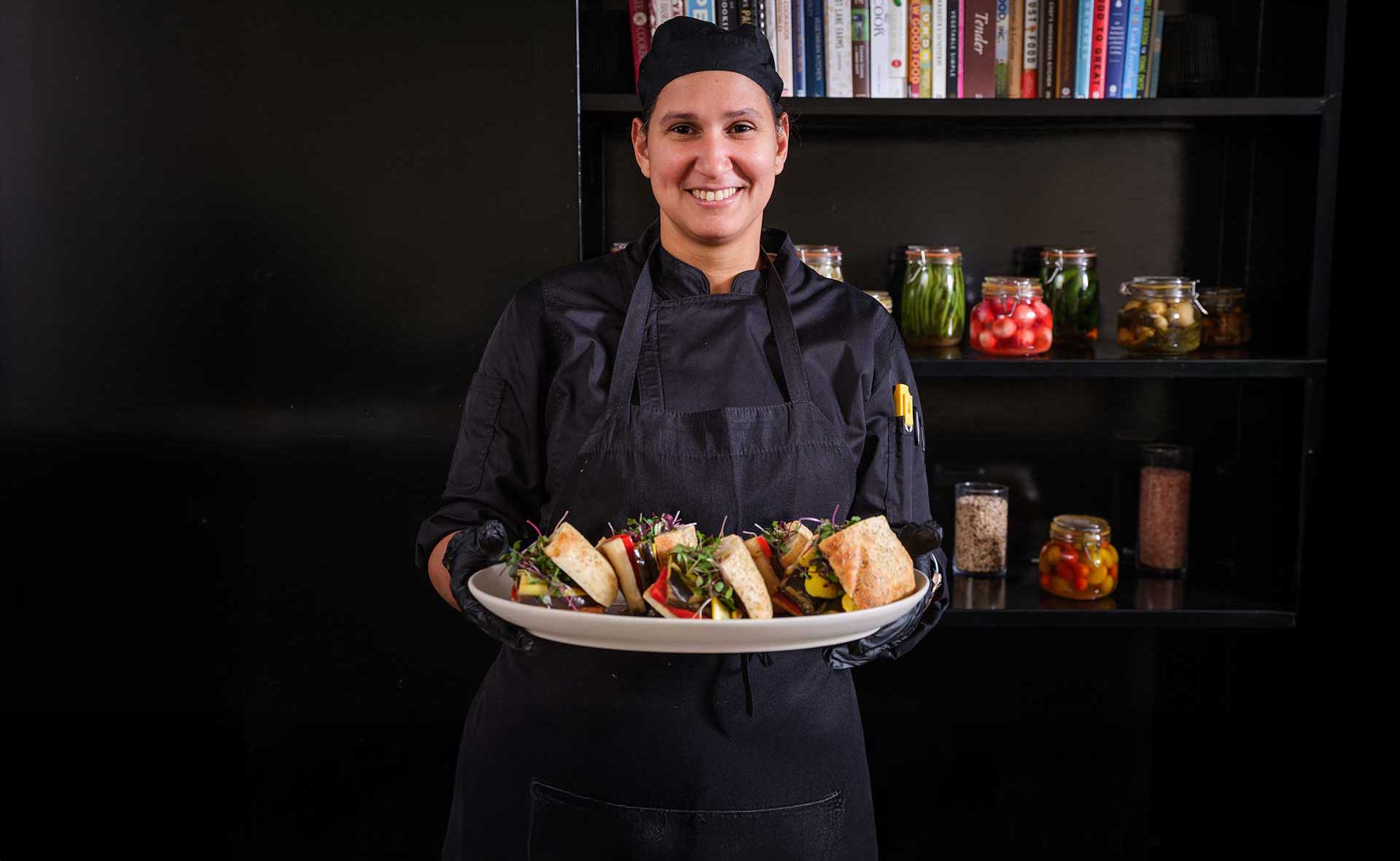 Friendly staff holding tray of sandwiches